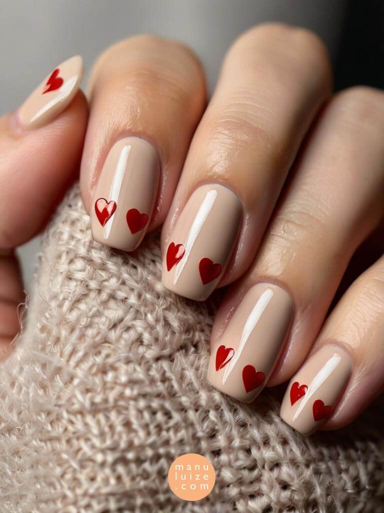 Nude nails with red glossy hearts